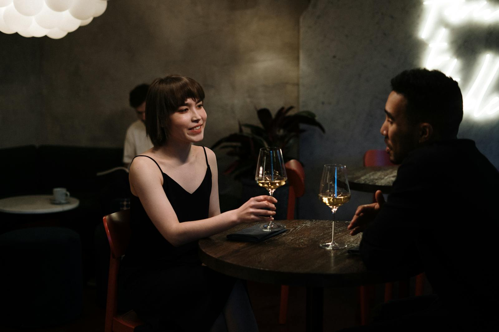 Couple enjoying a date night with white wine in a modern restaurant